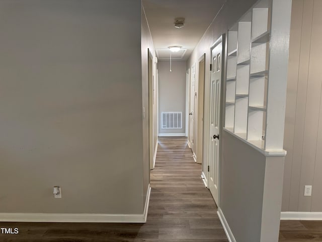 hallway featuring dark hardwood / wood-style flooring and wooden walls