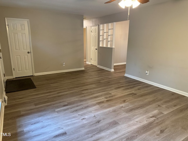 empty room with dark wood-type flooring and ceiling fan