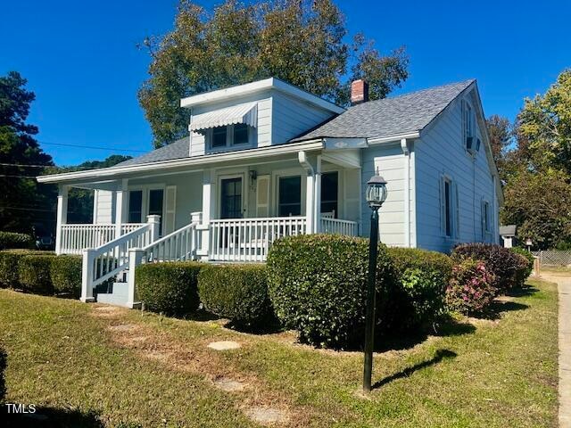 bungalow-style house featuring a front yard and covered porch