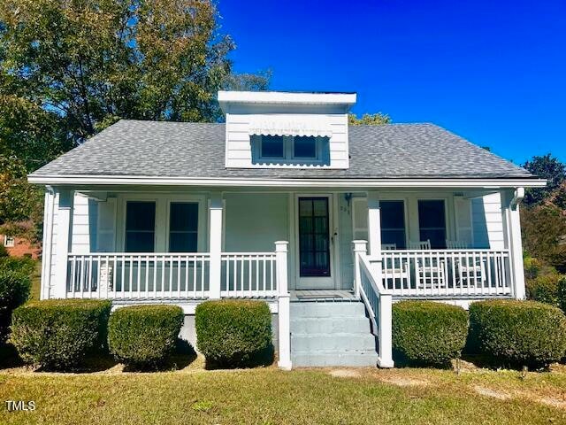 view of front of home with a porch and a front lawn