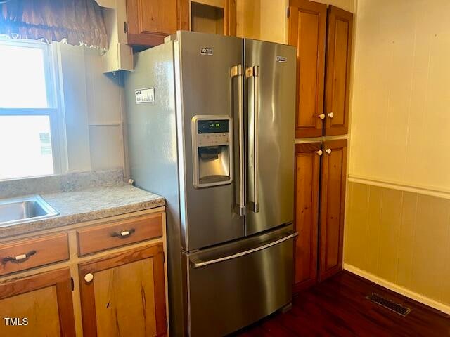 kitchen featuring high end refrigerator, wooden walls, sink, and dark hardwood / wood-style floors