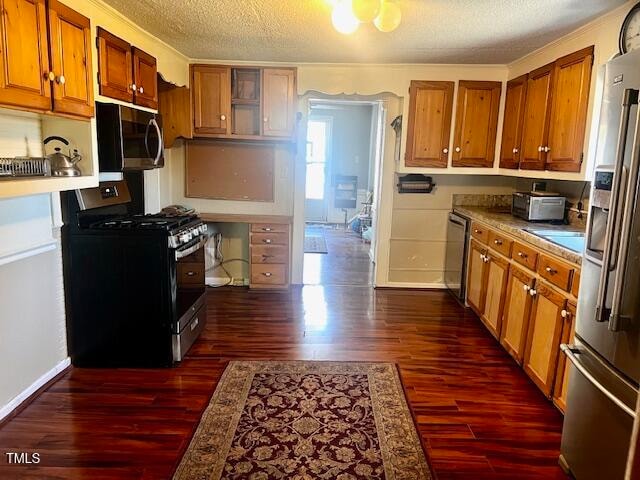 kitchen featuring dark hardwood / wood-style flooring, a textured ceiling, and stainless steel appliances