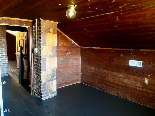 additional living space with wood walls, dark wood-type flooring, and wood ceiling