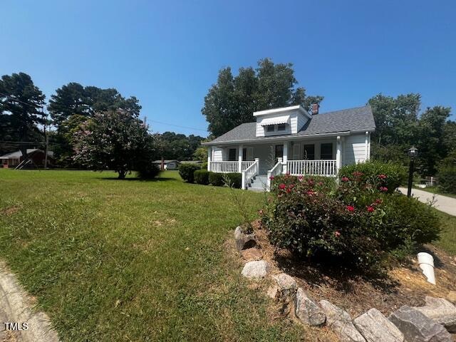 view of front of house with a front yard and a porch