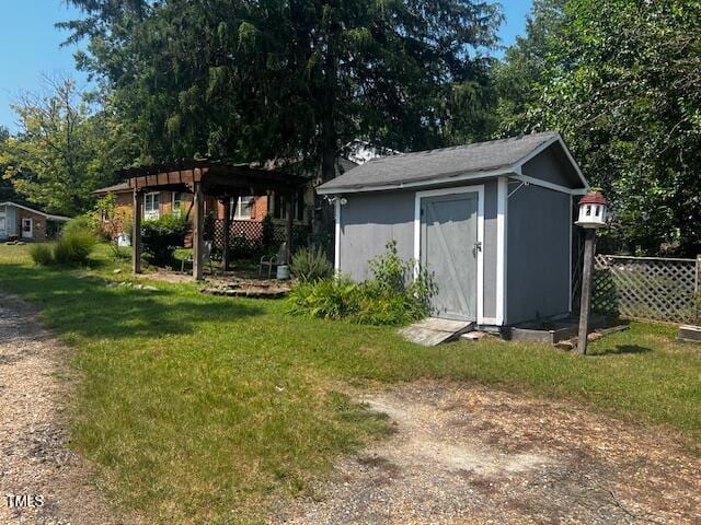 view of outbuilding with a lawn and a pergola