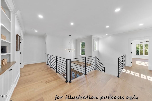 corridor featuring crown molding, a chandelier, and light wood-type flooring