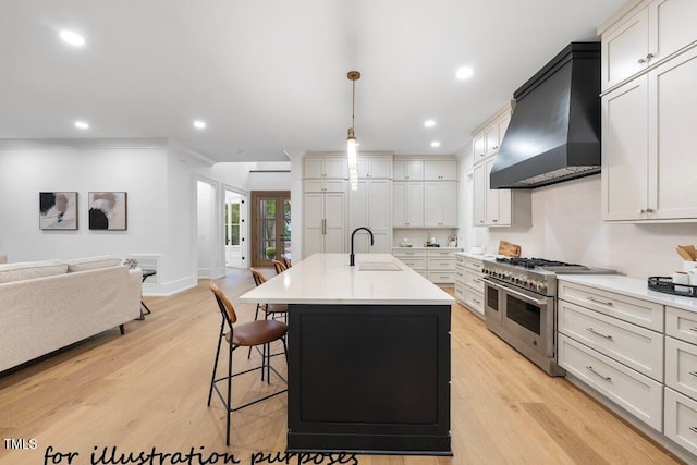 kitchen featuring decorative light fixtures, an island with sink, sink, double oven range, and custom range hood