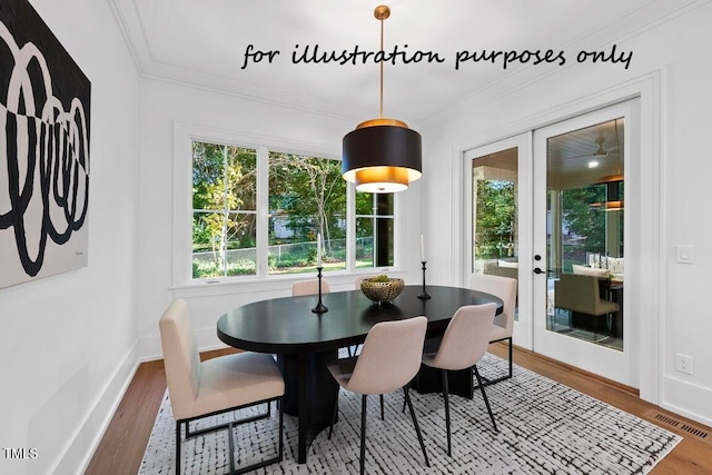 dining room featuring crown molding, hardwood / wood-style floors, and french doors