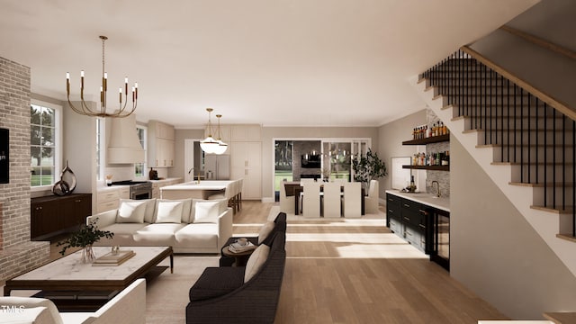 living room with ornamental molding, a chandelier, wet bar, and light wood-type flooring