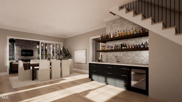 bar with backsplash, wine cooler, hanging light fixtures, light hardwood / wood-style floors, and crown molding