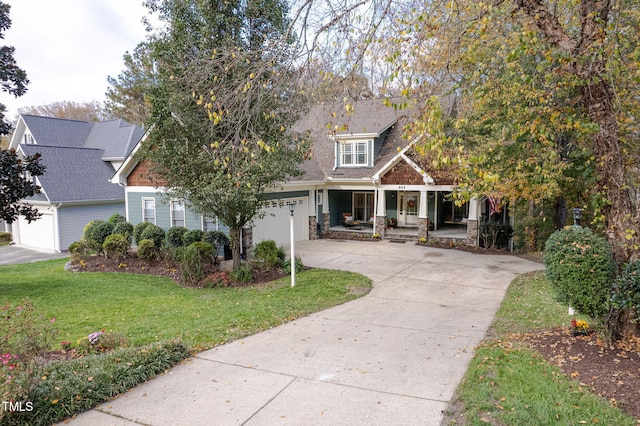 view of front of home with a front lawn, a porch, and a garage