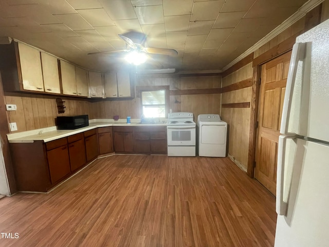 kitchen featuring washer / dryer, light wood-type flooring, wood walls, white appliances, and ceiling fan