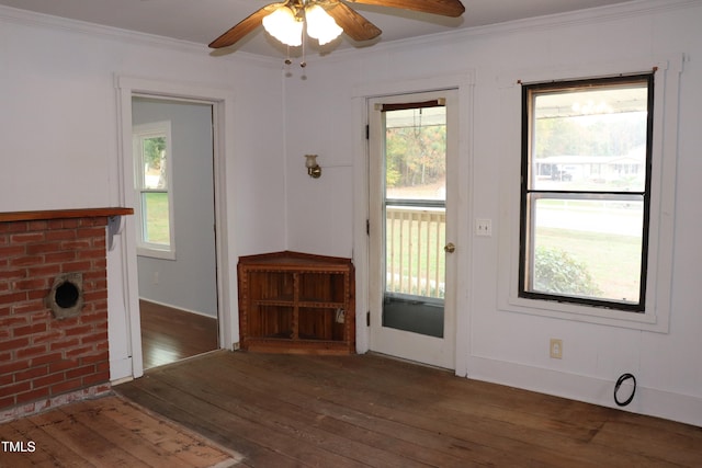 doorway to outside featuring a wealth of natural light, dark wood-type flooring, ceiling fan, and crown molding