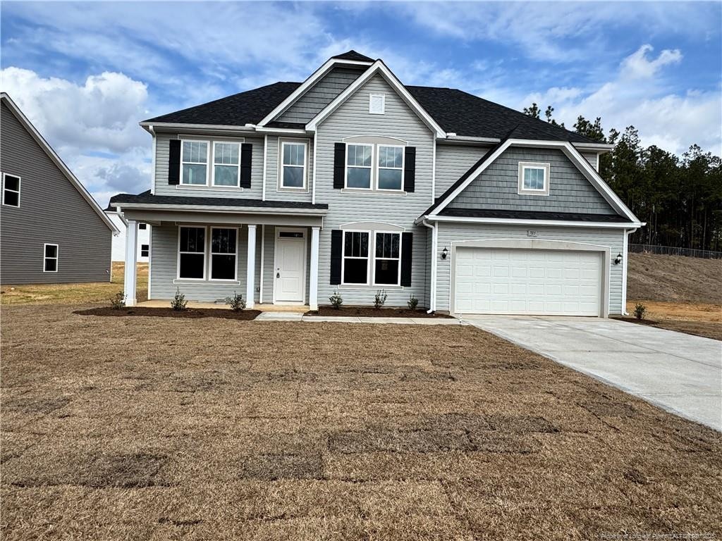 craftsman inspired home featuring a garage and a front lawn