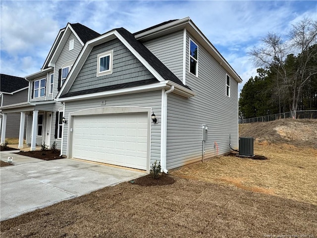 view of front of property with a garage and central AC