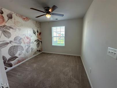 carpeted empty room featuring ceiling fan