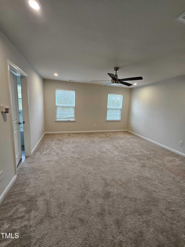 empty room featuring ceiling fan, carpet, and a healthy amount of sunlight