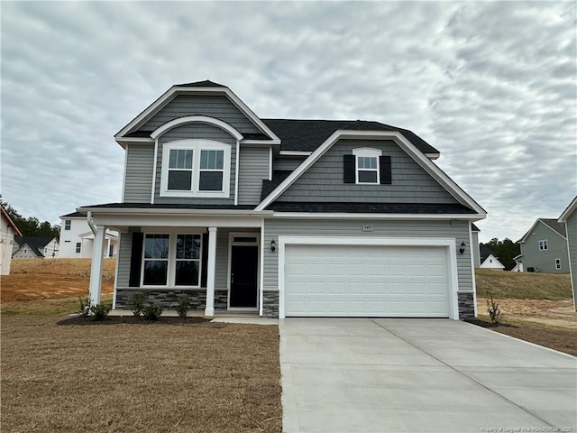 craftsman inspired home with a garage, a front lawn, and a porch