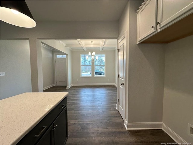 kitchen with coffered ceiling, light countertops, hanging light fixtures, dark cabinetry, and dark wood finished floors