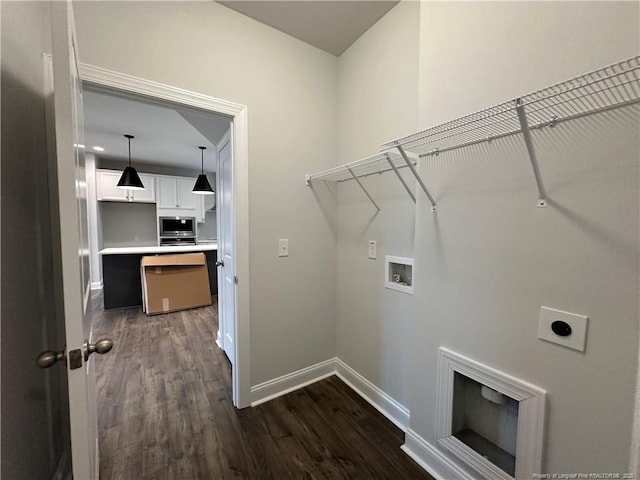 laundry area featuring dark wood finished floors, hookup for a washing machine, electric dryer hookup, laundry area, and baseboards