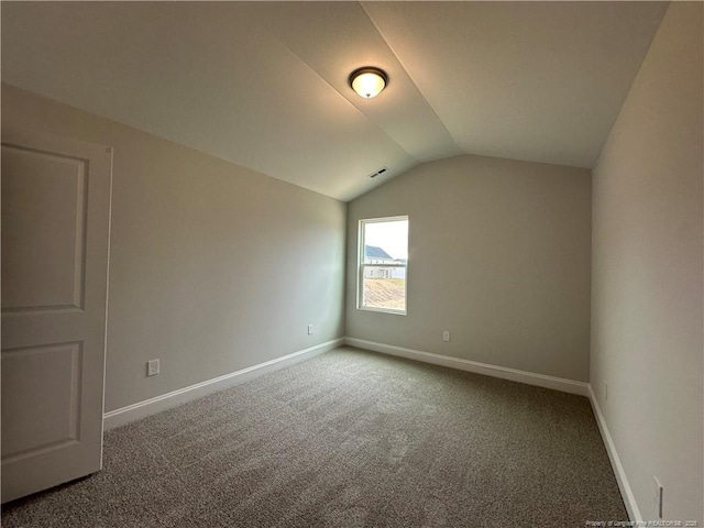 additional living space with carpet flooring, vaulted ceiling, visible vents, and baseboards