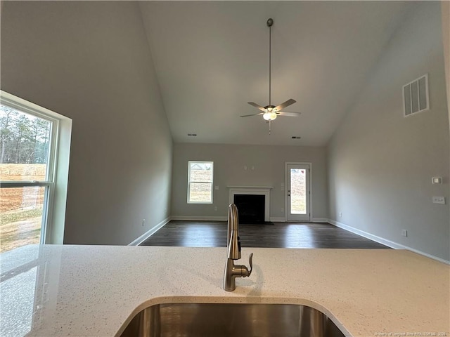 kitchen with a fireplace, a sink, visible vents, open floor plan, and dark wood-style floors