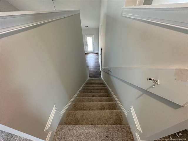 staircase featuring carpet flooring and baseboards