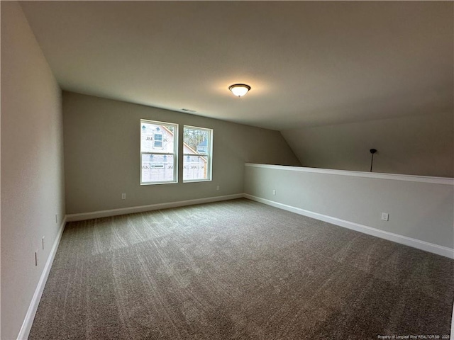 additional living space with carpet, visible vents, lofted ceiling, and baseboards