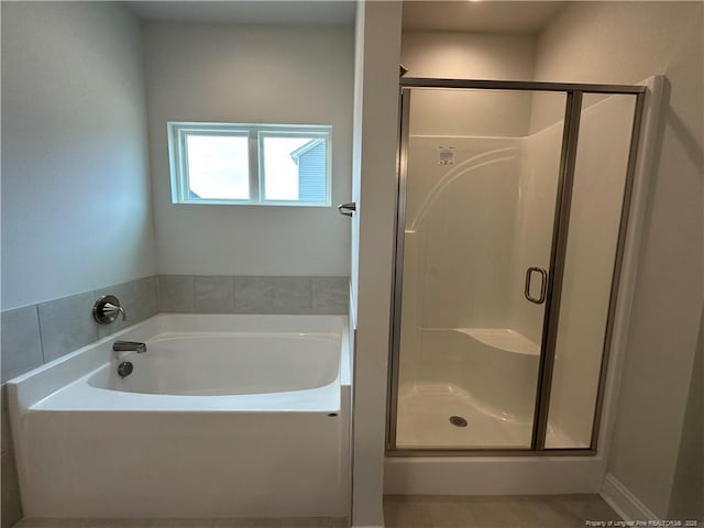 full bathroom featuring a stall shower and a garden tub