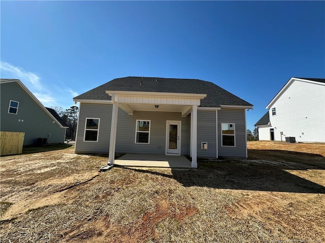 rear view of property featuring a patio area and a shingled roof