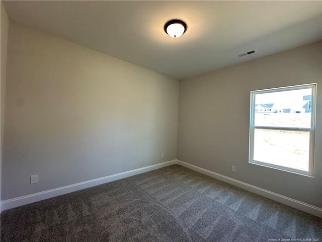 empty room featuring carpet, visible vents, and baseboards