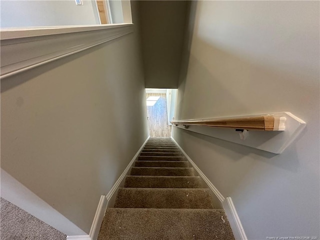 stairway featuring carpet and baseboards