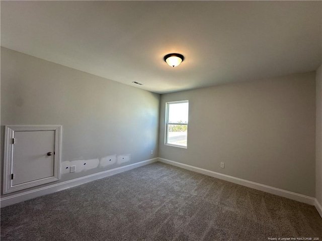 unfurnished room featuring carpet, visible vents, and baseboards