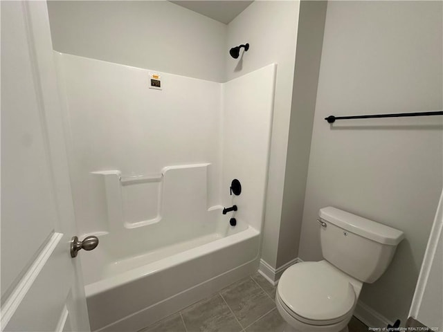 bathroom featuring shower / washtub combination, toilet, and baseboards