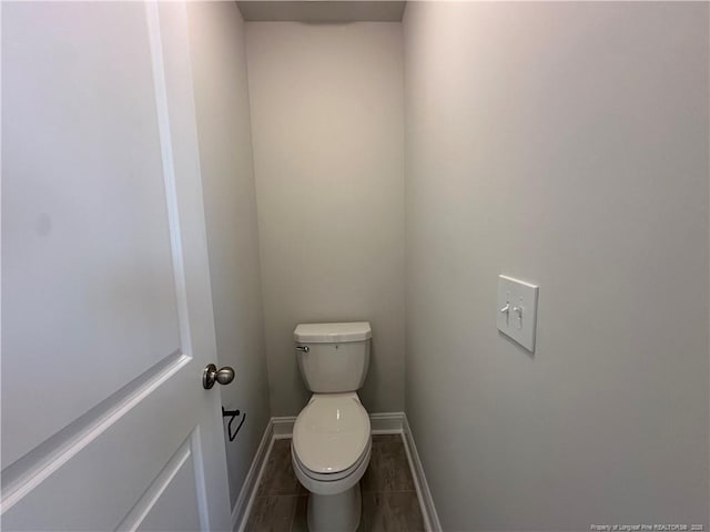 bathroom with tile patterned flooring, toilet, and baseboards