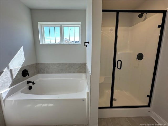 full bathroom featuring a garden tub and a shower stall