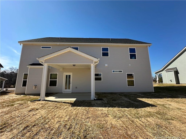 back of property with a patio area and a yard