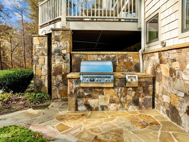 view of patio featuring an outdoor kitchen, a grill, and a balcony