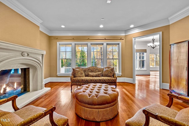 living area with a wealth of natural light, light hardwood / wood-style floors, and crown molding