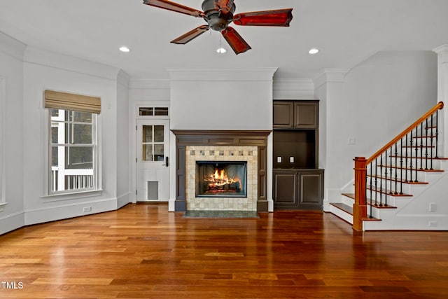 unfurnished living room with hardwood / wood-style floors, ornamental molding, and a fireplace