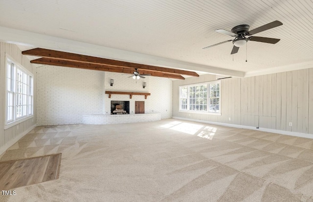 203 W Stewart St, Coats, NC 27521 - unfurnished living room featuring ceiling fan, healthy amount of natural light, carpet floors, beam ceiling, and brick wall