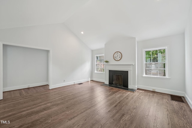 1316 Glenwood Ave, Raleigh, NC 27605 - unfurnished living room with a fireplace with raised hearth, vaulted ceiling, a healthy amount of sunlight, and wood finished floors