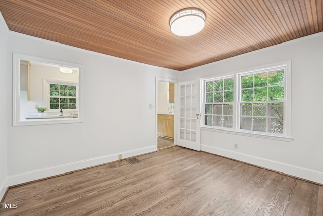 1316 Glenwood Ave, Raleigh, NC 27605 - empty room featuring baseboards, wood finished floors, a wealth of natural light, and wooden ceiling