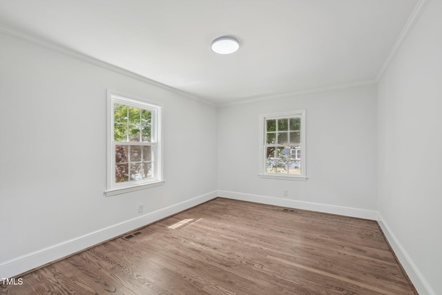 1316 Glenwood Ave, Raleigh, NC 27605 - spare room with crown molding, baseboards, wood finished floors, and visible vents