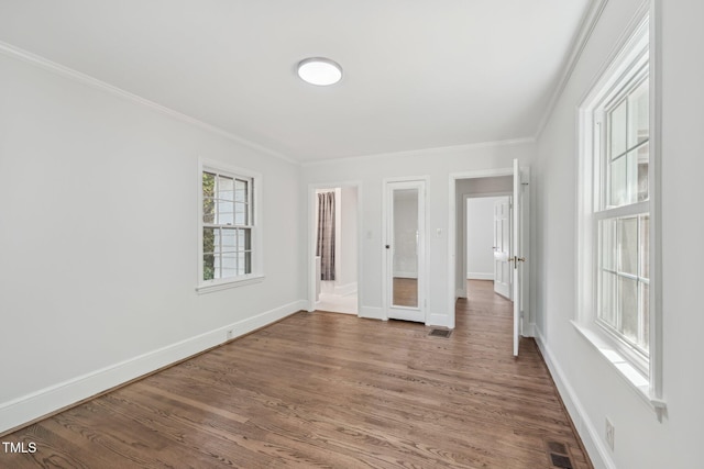 1316 Glenwood Ave, Raleigh, NC 27605 - unfurnished bedroom featuring visible vents, baseboards, crown molding, and wood finished floors