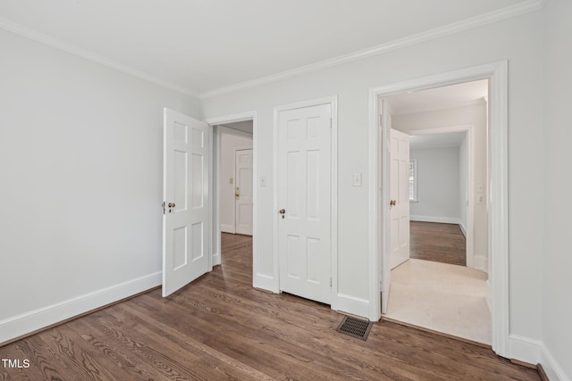 1316 Glenwood Ave, Raleigh, NC 27605 - unfurnished bedroom featuring crown molding, baseboards, visible vents, and wood finished floors