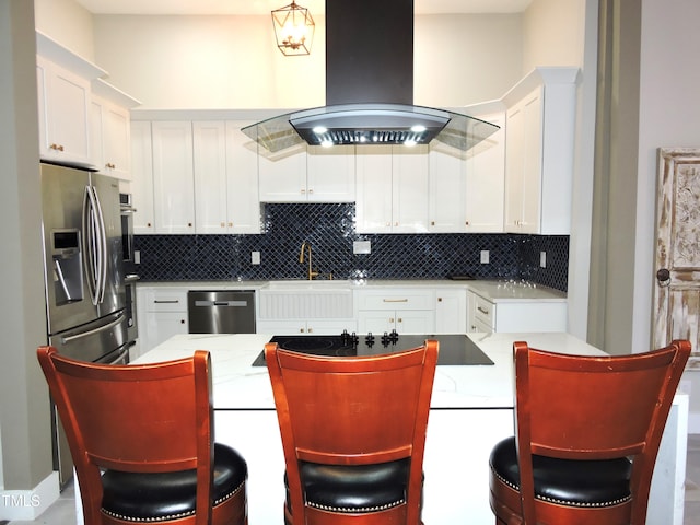 kitchen featuring white cabinets, stainless steel appliances, tasteful backsplash, and island range hood