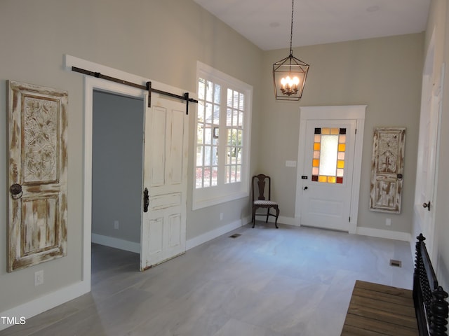 entrance foyer featuring a barn door and a notable chandelier