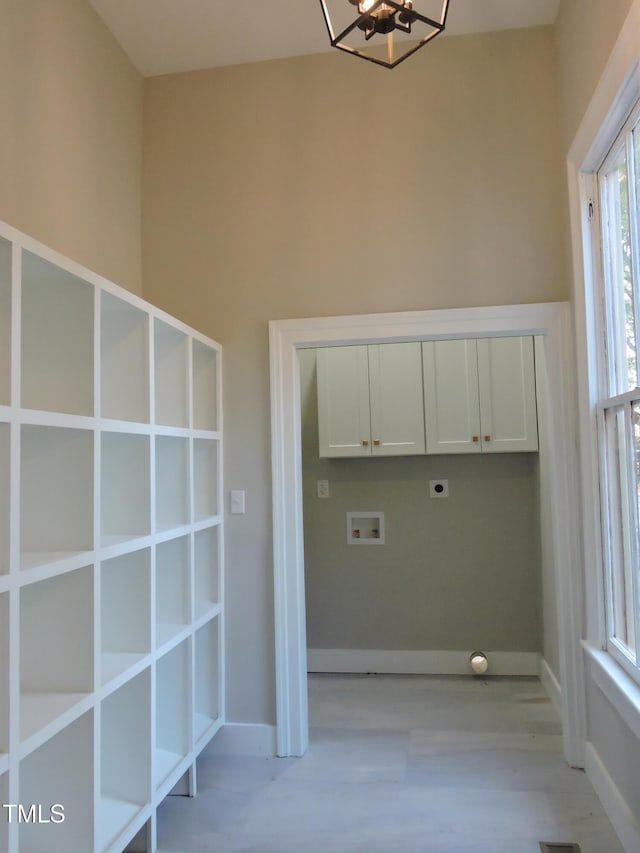 clothes washing area with hookup for an electric dryer, cabinets, a notable chandelier, washer hookup, and light hardwood / wood-style flooring