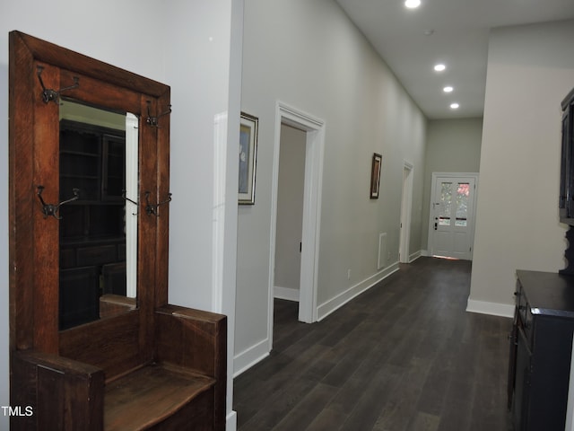 corridor with dark hardwood / wood-style floors and a high ceiling